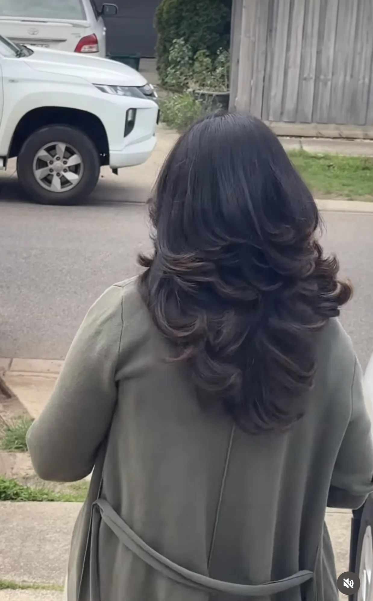 Rear view of glossy layered blow-dry finish, olive coat, outdoor driveway
