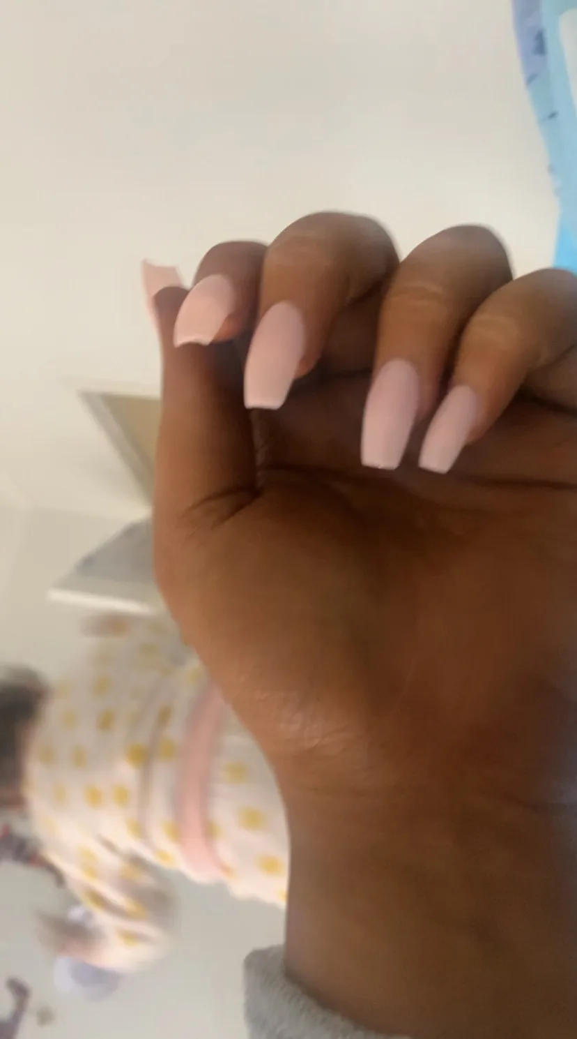 Close-up of a hand showing a blush coffin-shape sculpted acrylic nail set